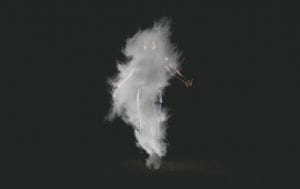 a silhouette of a person behind smoke on a black background
