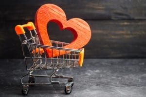 a red wooden heart in a shopping cart