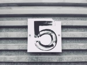 a sign displaying the number 5 on a metal door