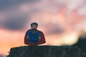 lego superman, a hero, with a sunset in the background