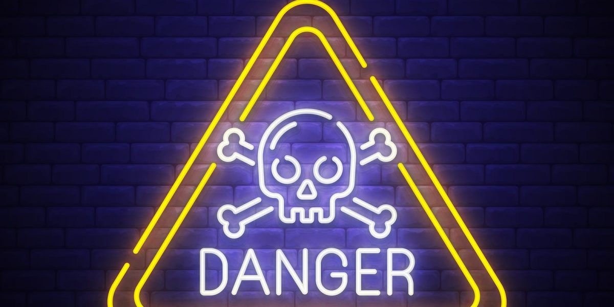A triangle neon sign with a skull and cross bones and the word "Danger"