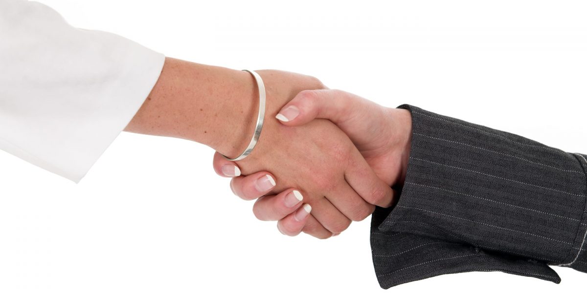 a closeup of two women shaking hands on a white background