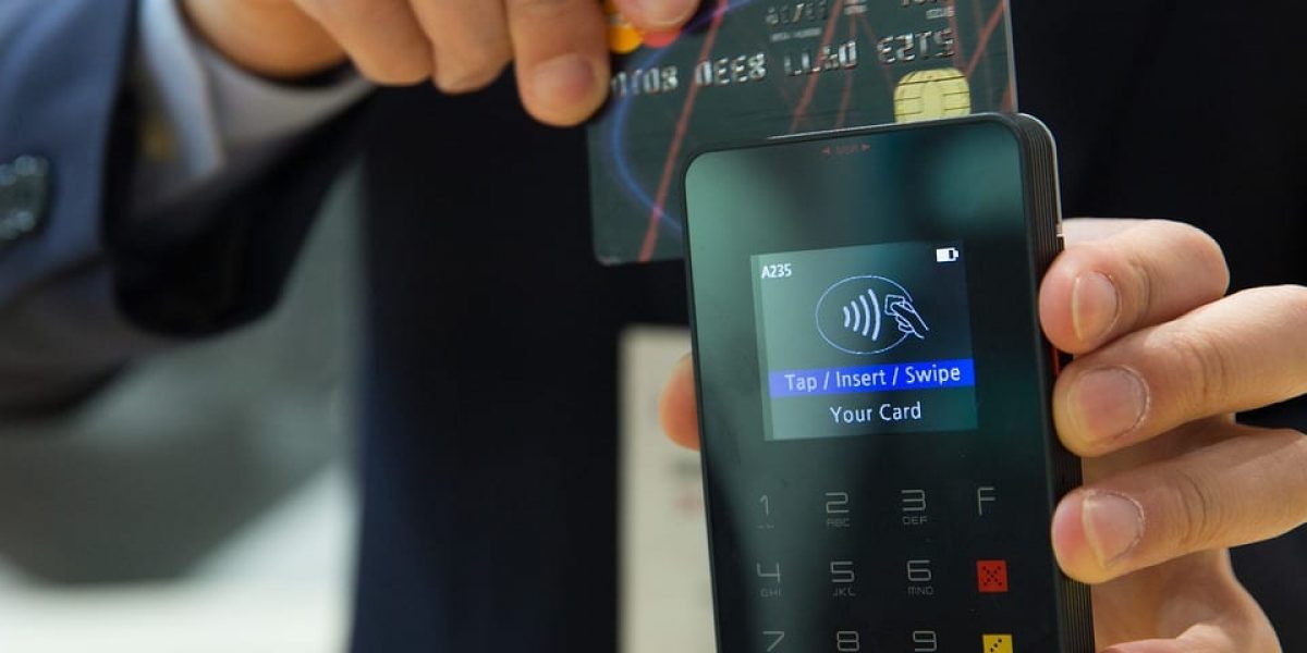 A man scanning a credit card through a card reading machine