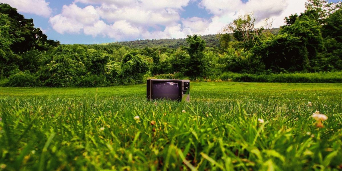 a photo of a television in a grassy field