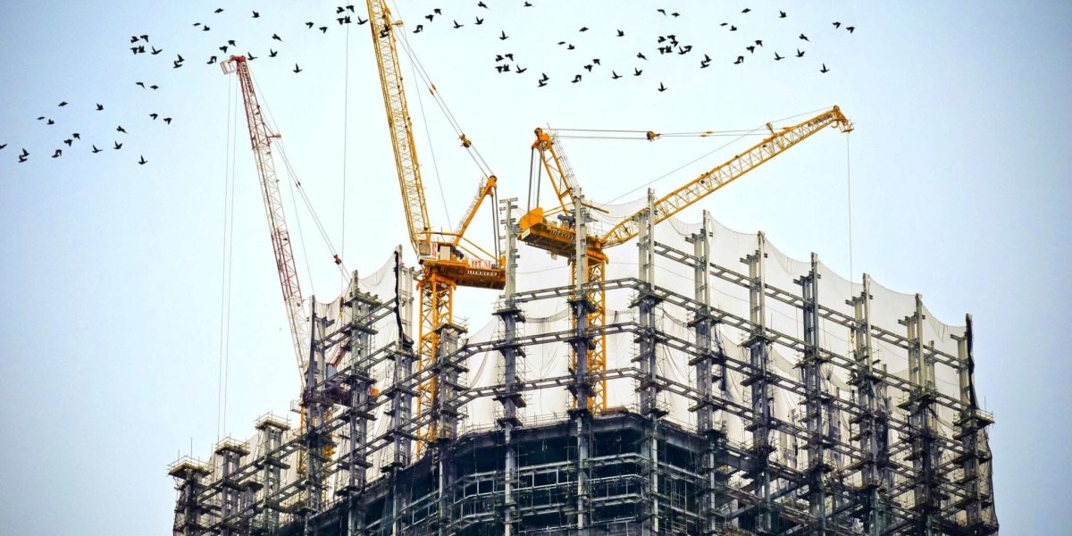 cranes on a large building under construction