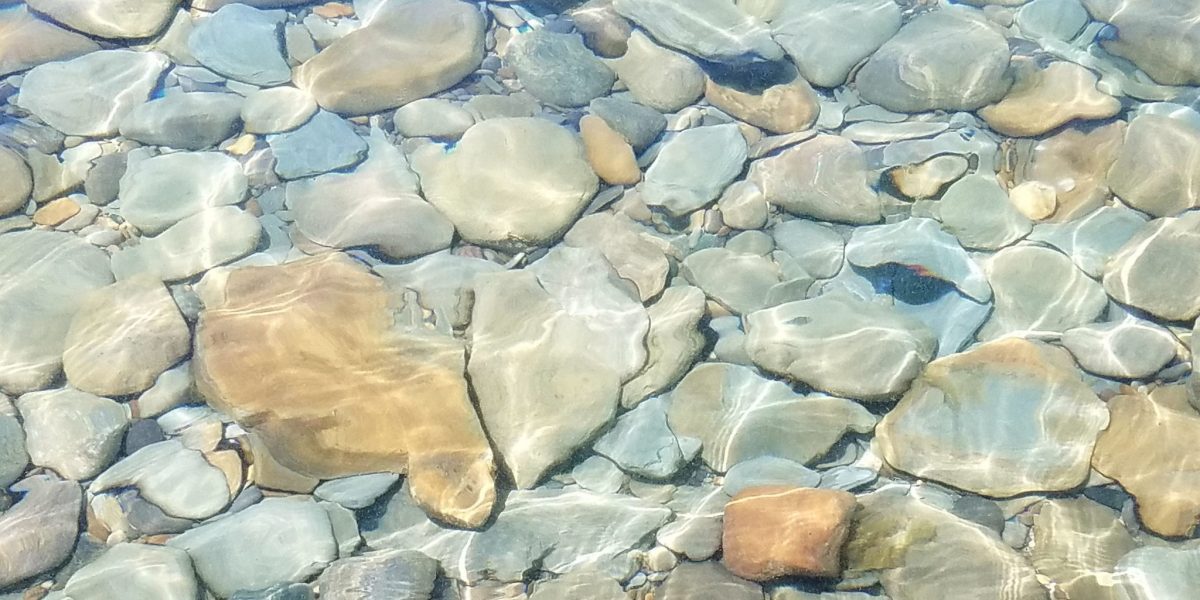 a clear pool of water with rocks at the bottom to represent clarity of vision