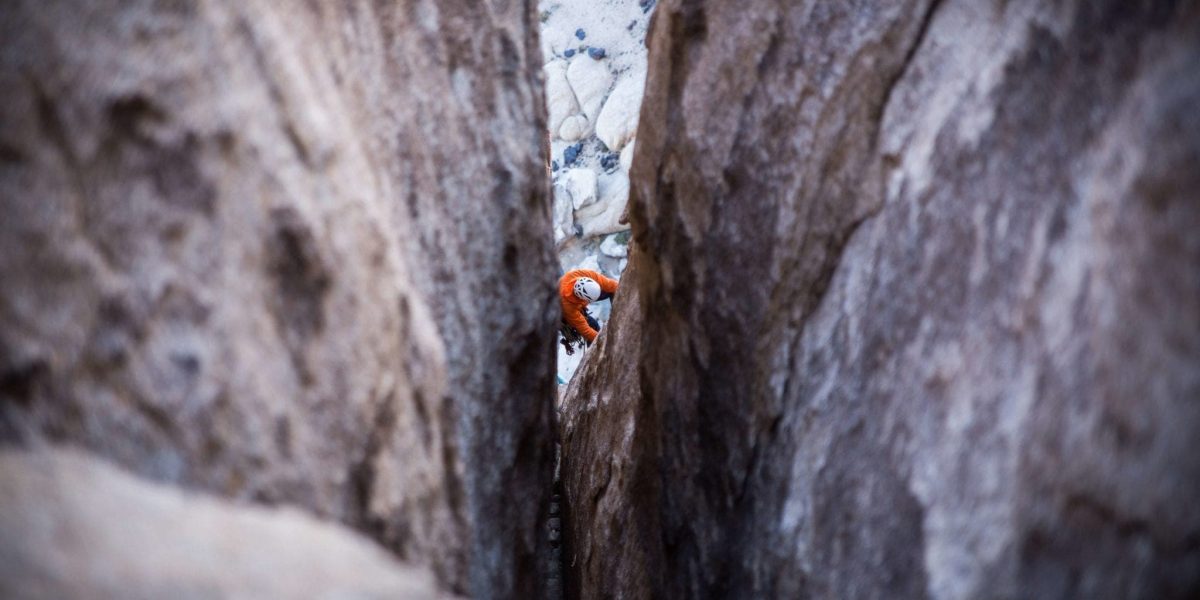 a person rock climbing in a crevasse